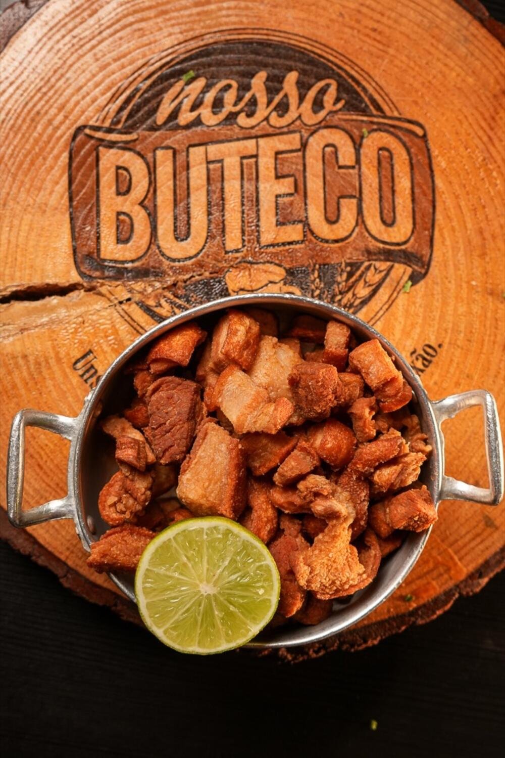 Torresmo servido na tábua com o logo Nosso Buteco